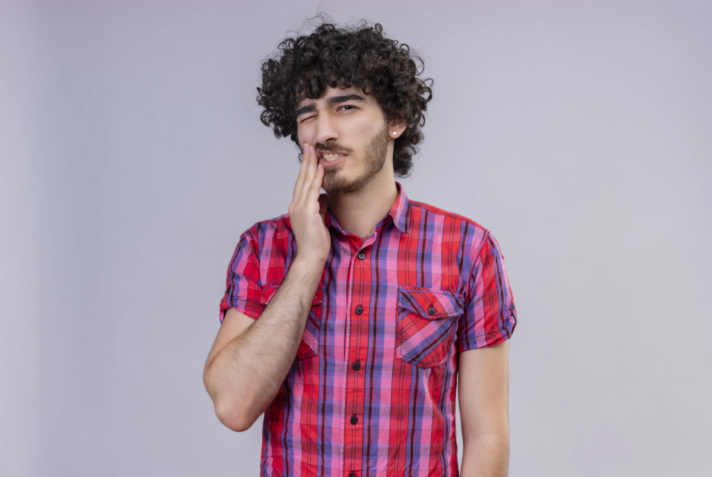sad-handsome-man-with-curly-hair-checked-shirt-feeling-ache-teeth